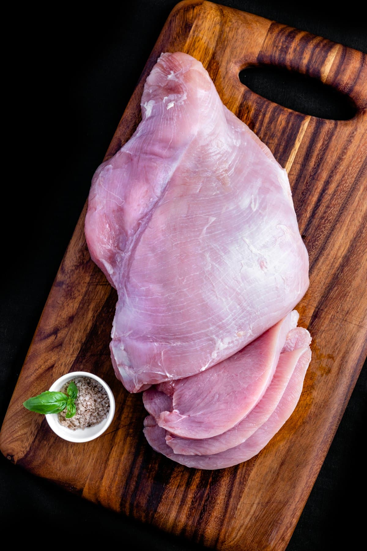 Raw chicken breast on a wooden board